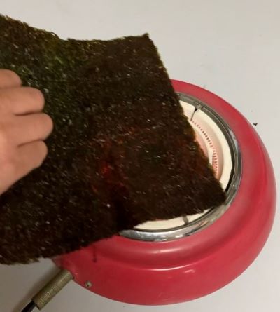 電気コンロで海苔を焼いている